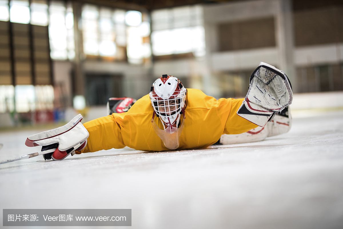 顽皮的冰球守门员在溜冰场的胃上滑行。