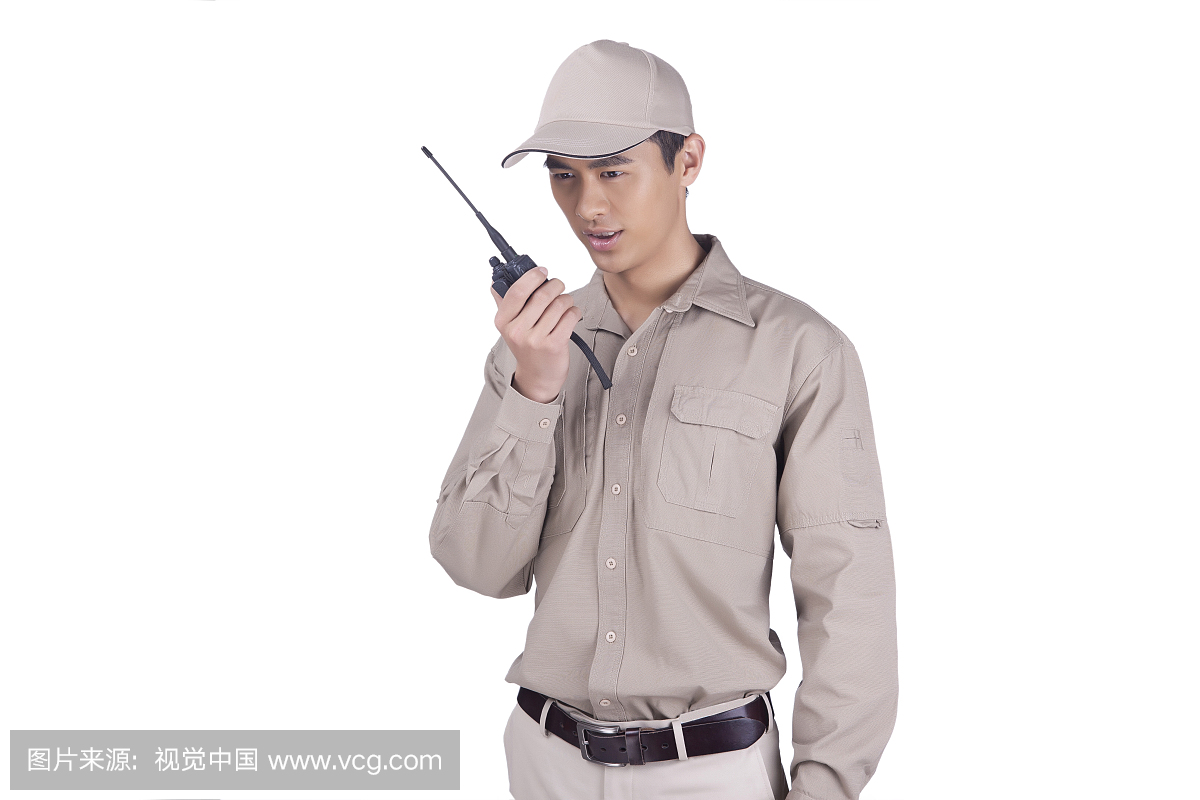 一个穿着工作服用对讲机的青年快递员
