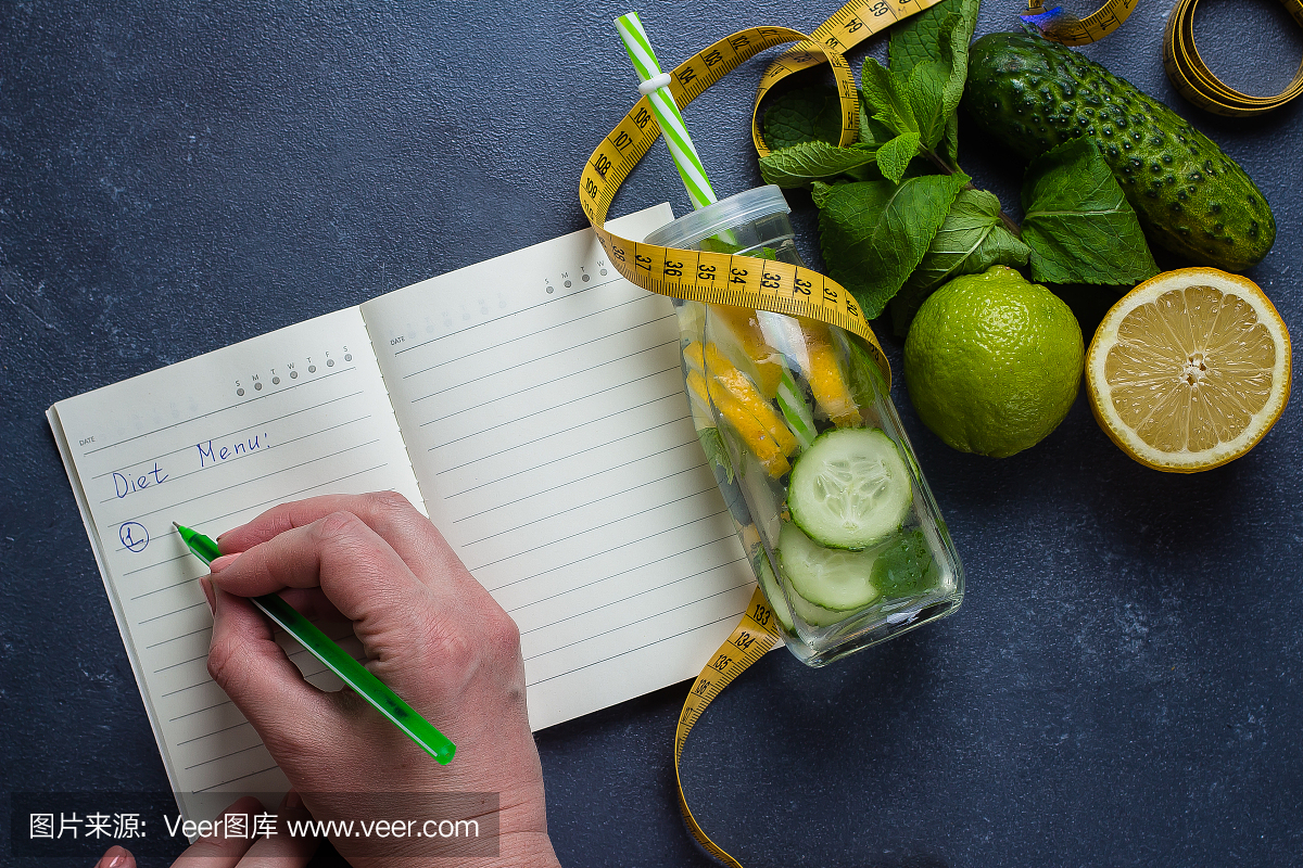 女人写营养计划饮食菜单和健身锻炼日常工作。