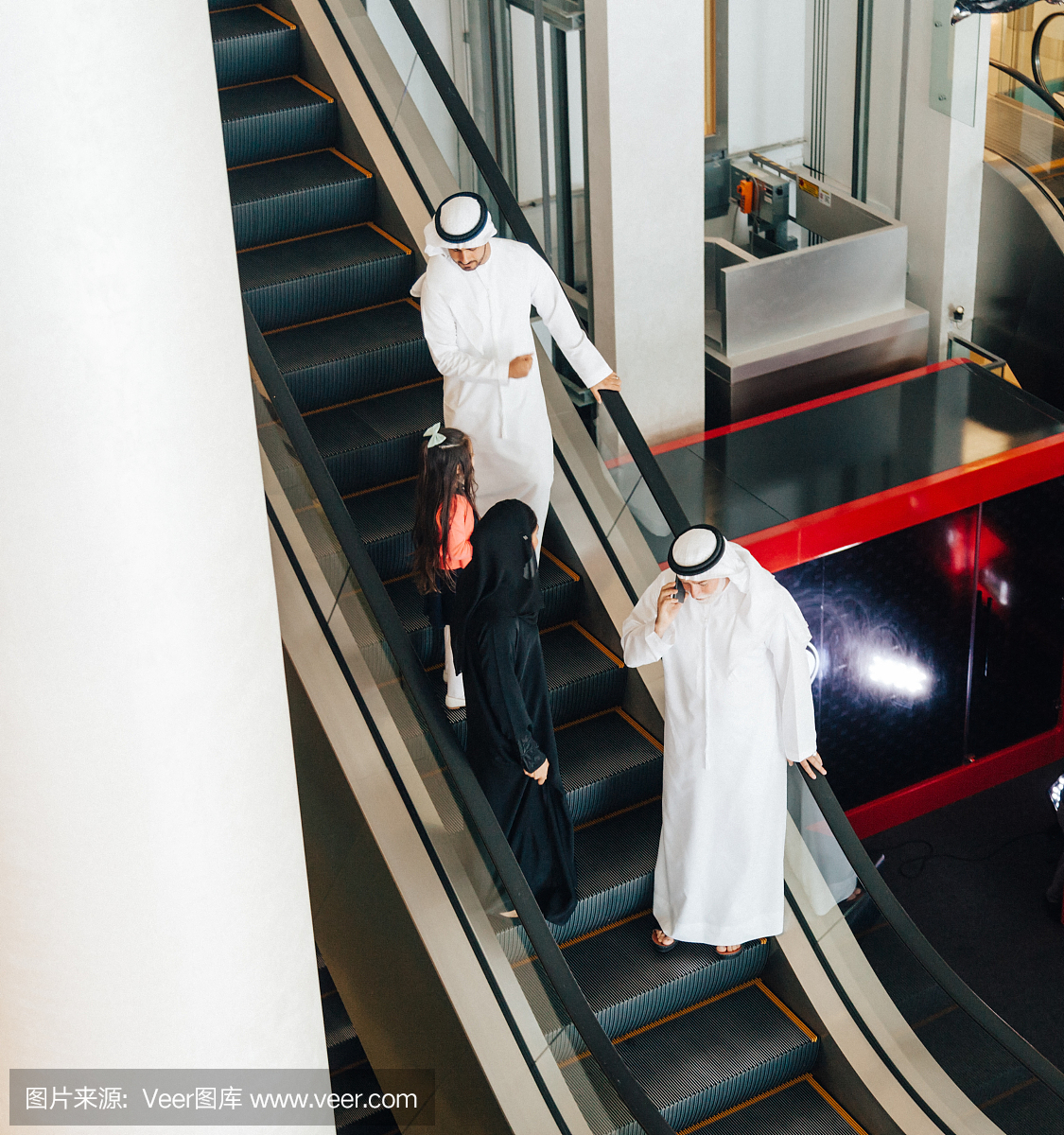 阿拉伯家庭在商场的自动扶梯上。