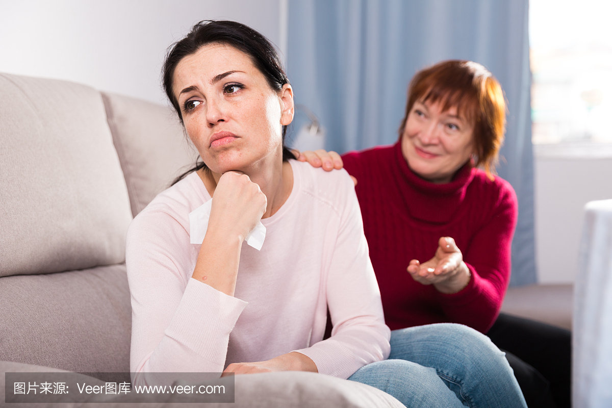 在家里冲突后坐在沙发上的不快乐的妇女