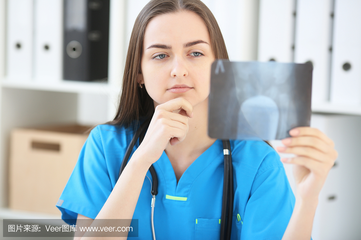 一名严重看病的女医生检查X光片
