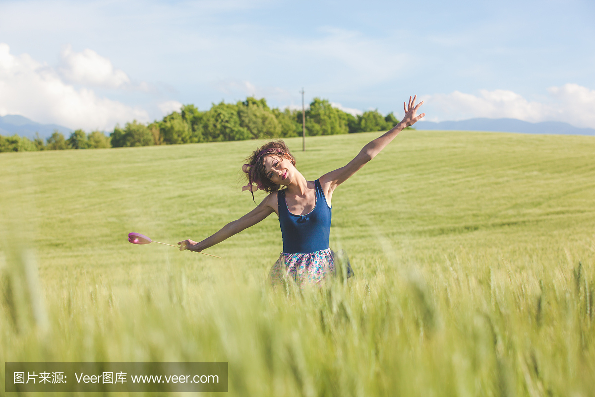 美丽的女人梦见棒棒糖在春天的田野