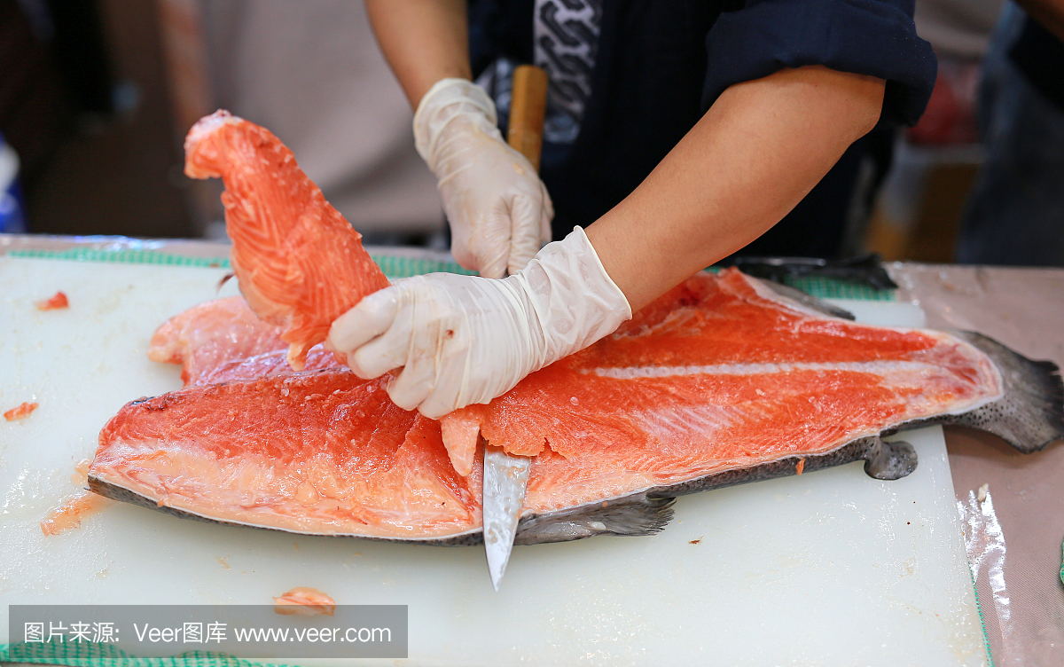 日本厨师在切生鱼三文鱼寿司的餐厅。厨师准备
