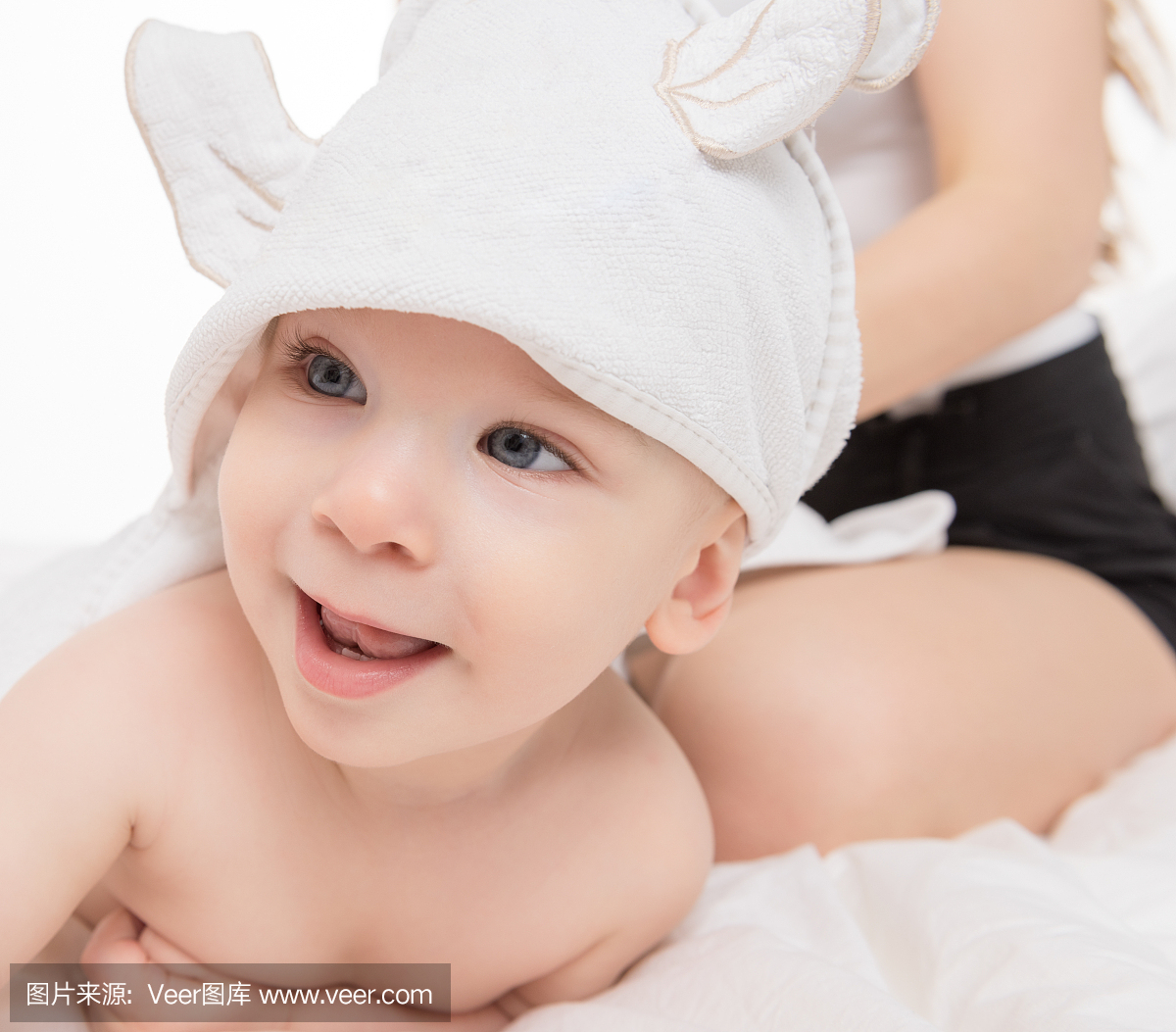 快乐宝贝男孩戴着头巾躺在浴缸或淋浴后的床上