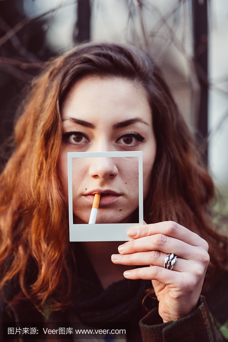 吸烟者持有即时照片,显示吸烟对皮肤的伤害
