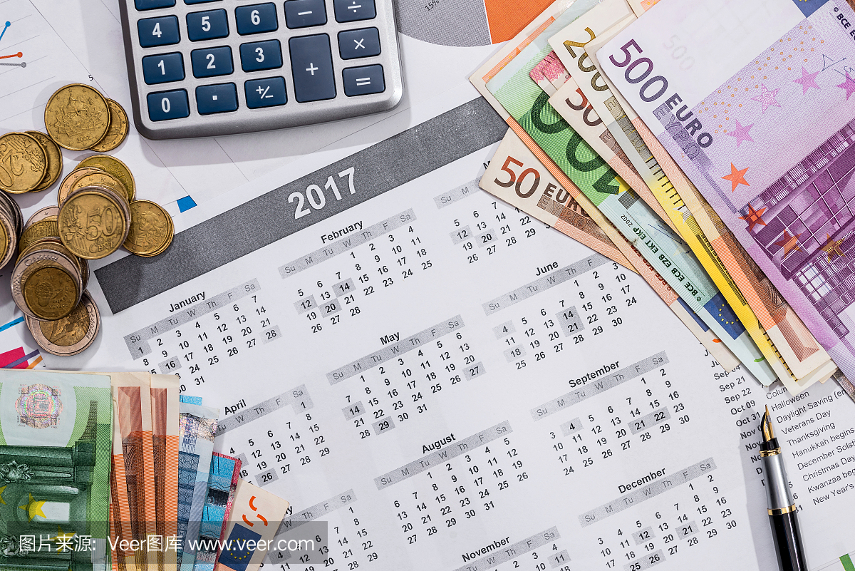 2017日历,笔,欧元单据和计算器放在桌子上。