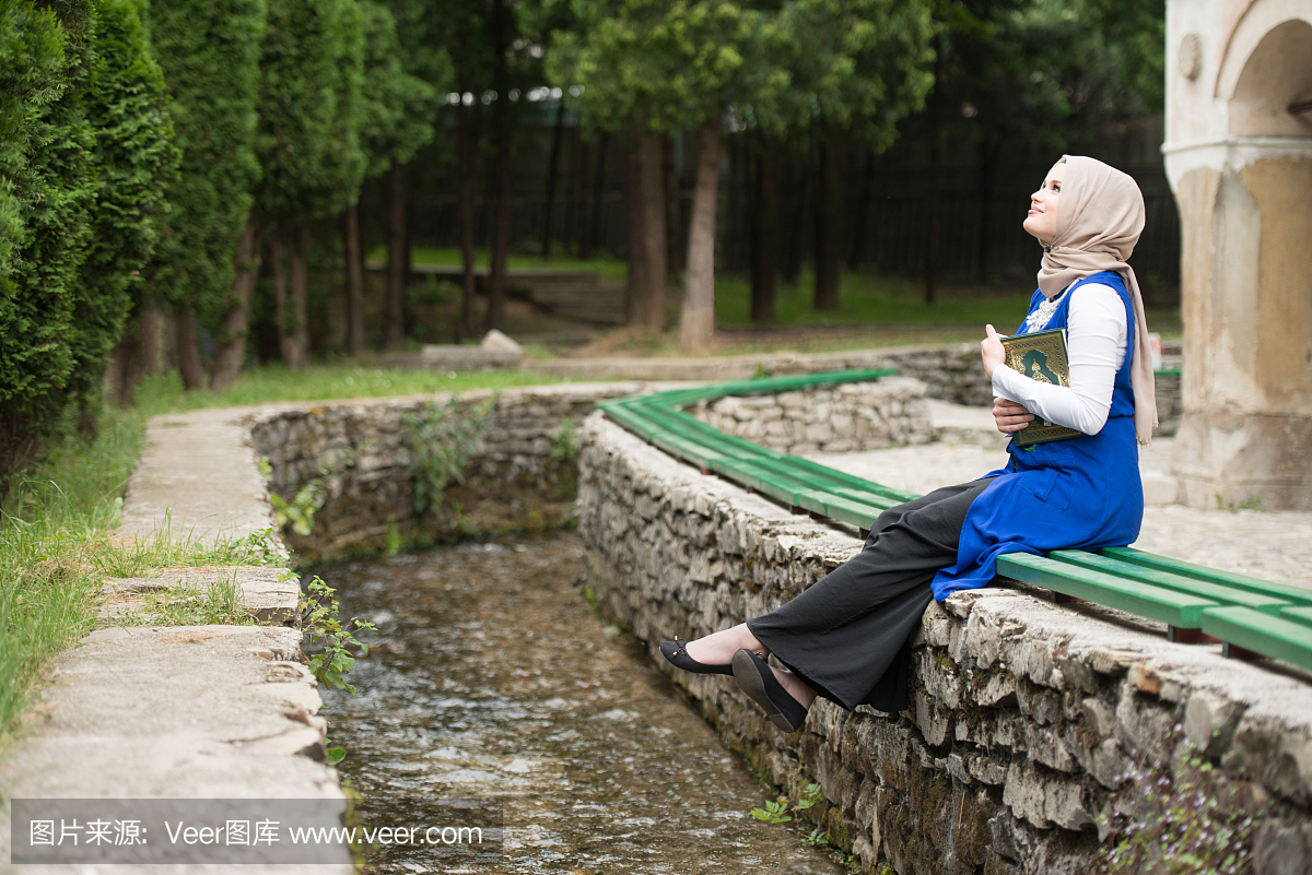 年轻的穆斯林妇女读圣经伊斯兰书古兰经