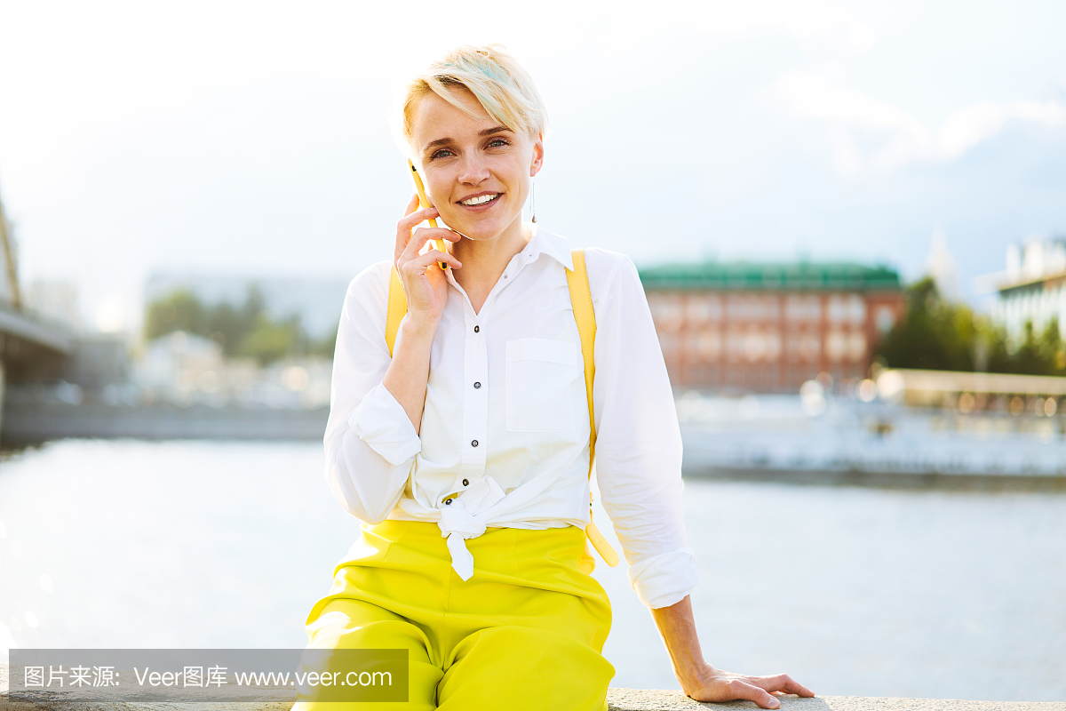 肖像的快乐时髦女孩短发型微笑在相机同时沟通