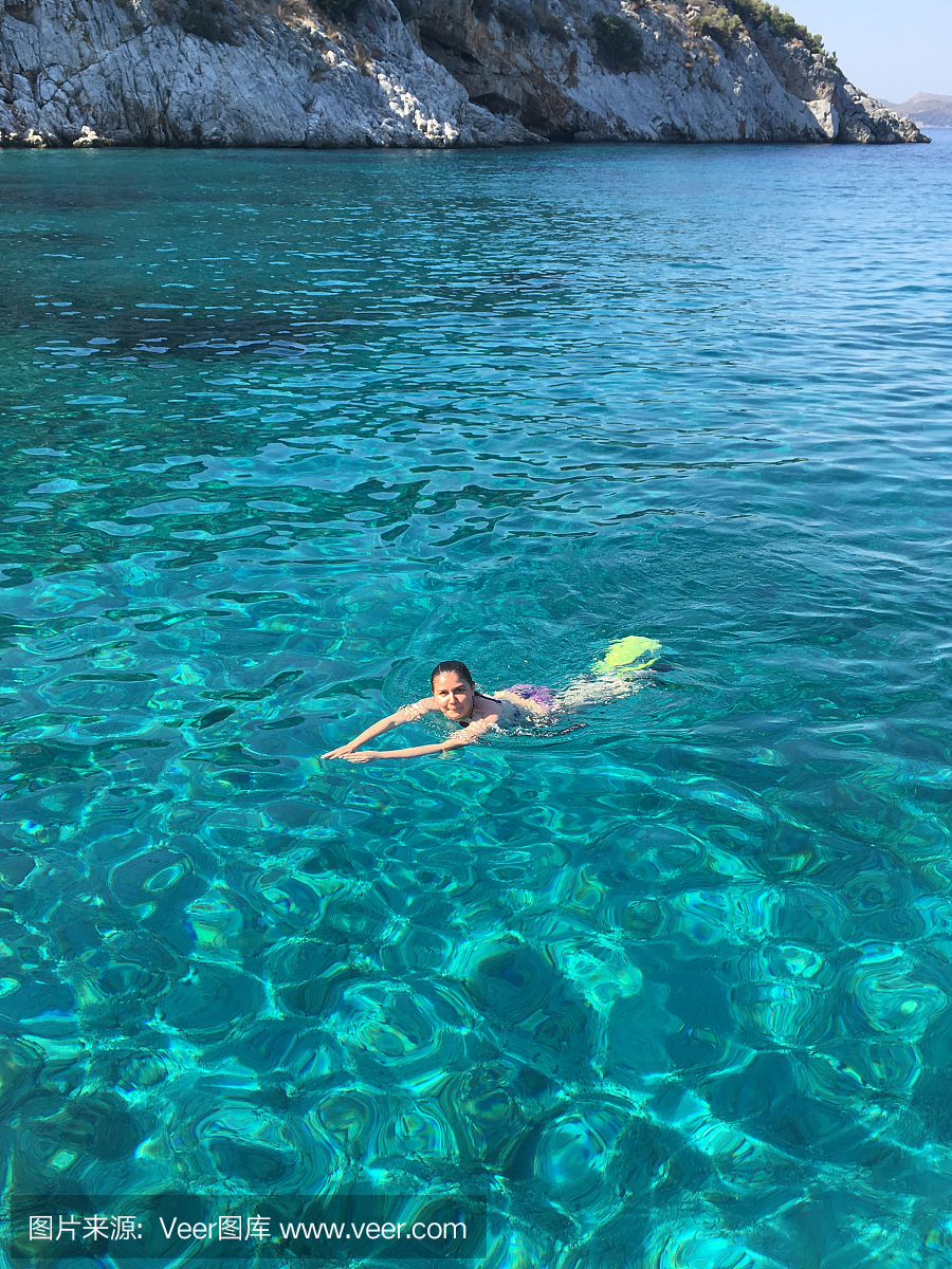 比基尼泳装的年轻女子在透明的浅海浮潜