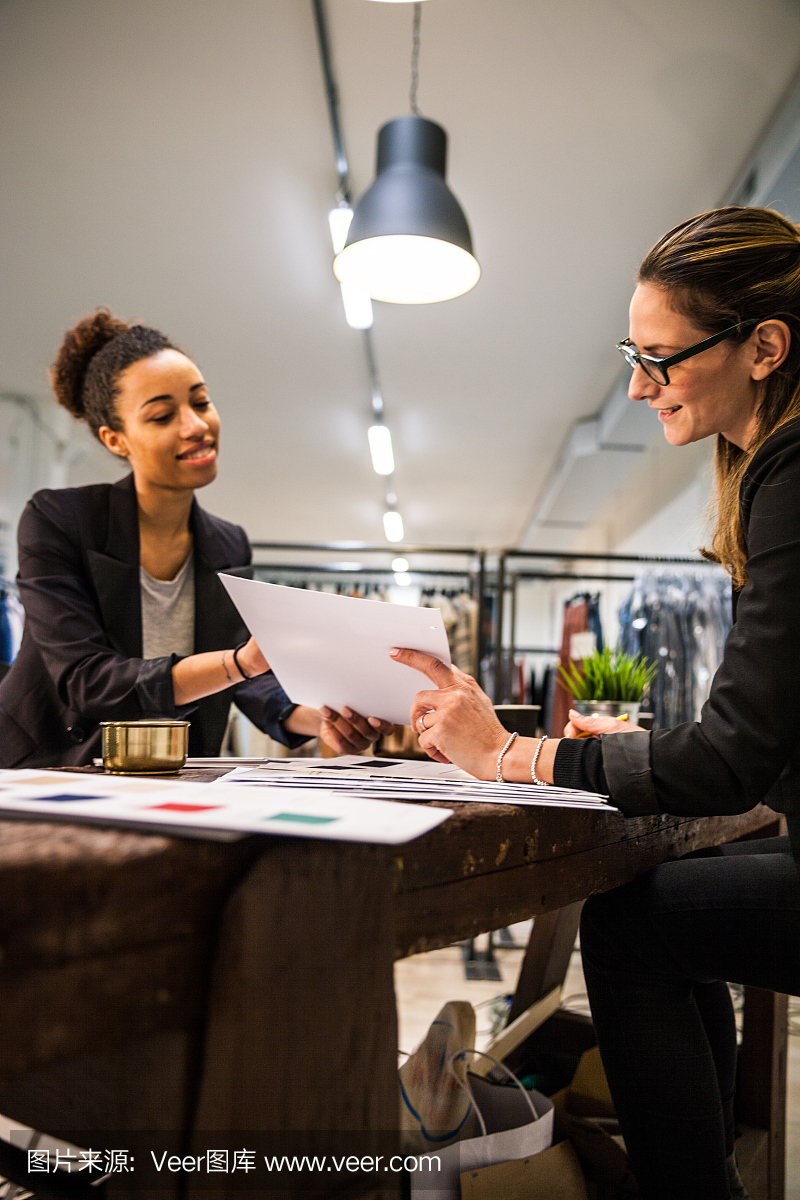 新商务服装店,妇女在工作上签约