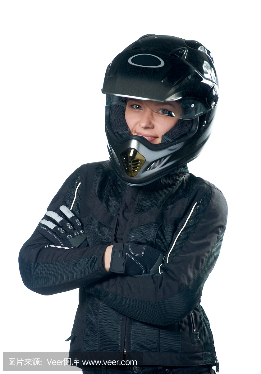 摆在摩托车服装和头盔的年轻美丽的女人