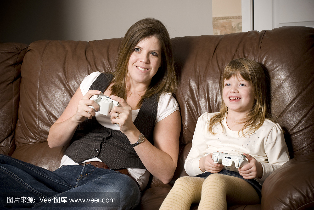 母亲和女儿玩视频游戏机
