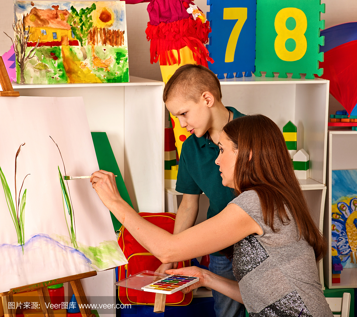 儿童绘画手指在画架上。孩子男孩学画画学校。