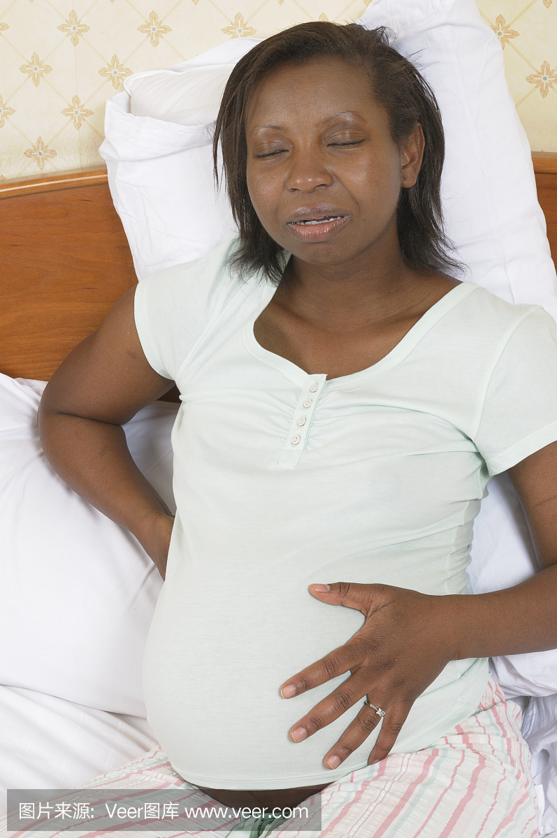 怀孕的非洲裔美国女人背部疼痛抱着她的肚子