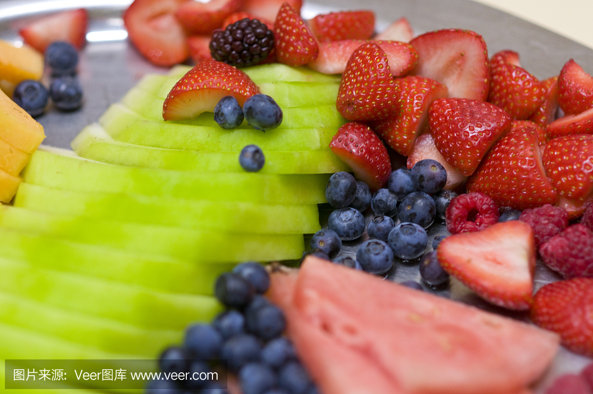 新鲜水果托盘与各种浆果和切片蜜汁