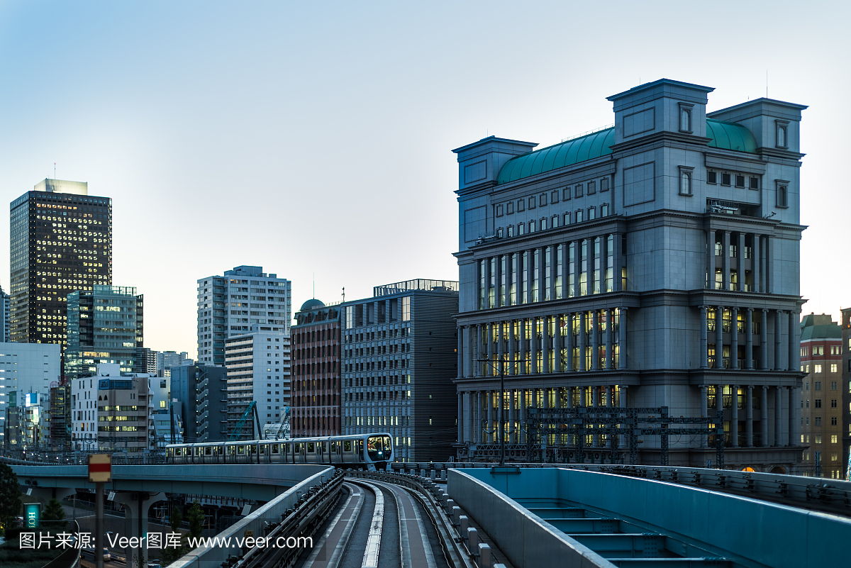在黄昏的东京单轨列车与建筑物和火车