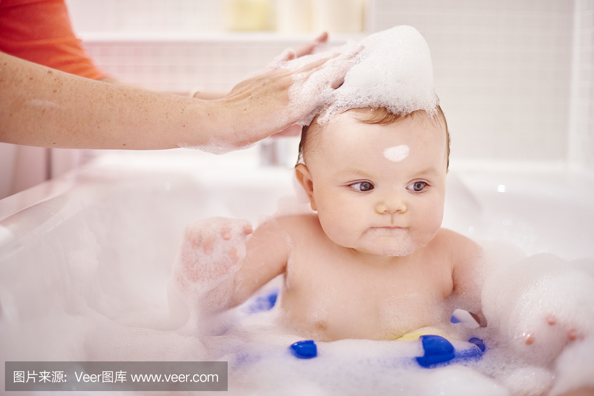 男婴坐在浴缸里洗头发