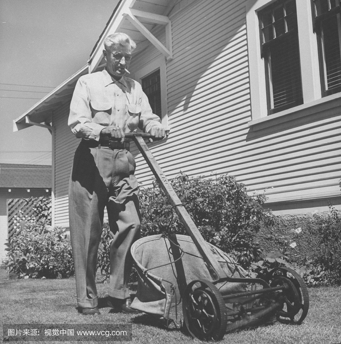 退休的铁路男子穿着休闲裤和一个运动衫推着割