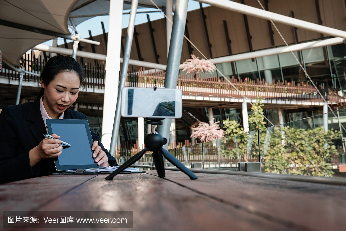女实业家使用智能手机在线直播。女人录制视频