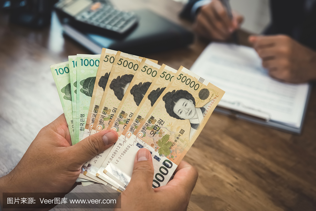 人拿着钱的手,韩元赢了货币,同时与他的伙伴签