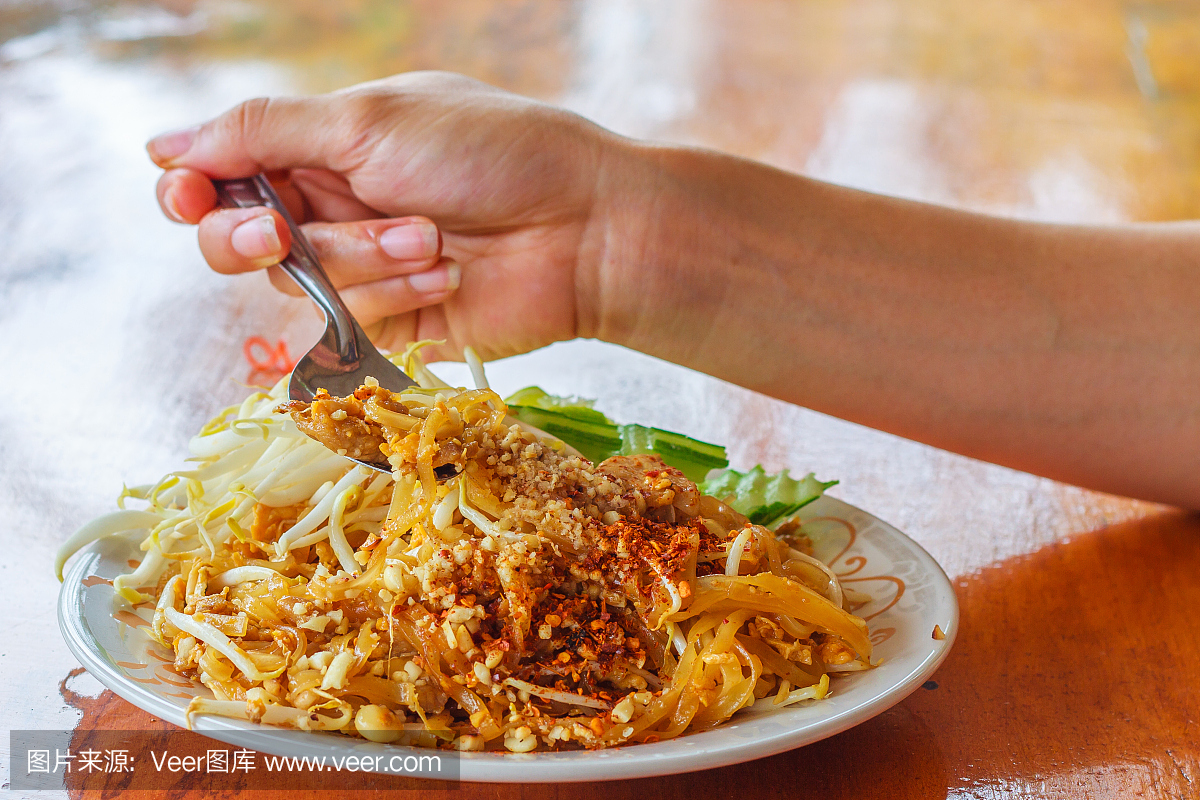 泰国食物垫泰国,搅拌与木制的桌子上虾面条