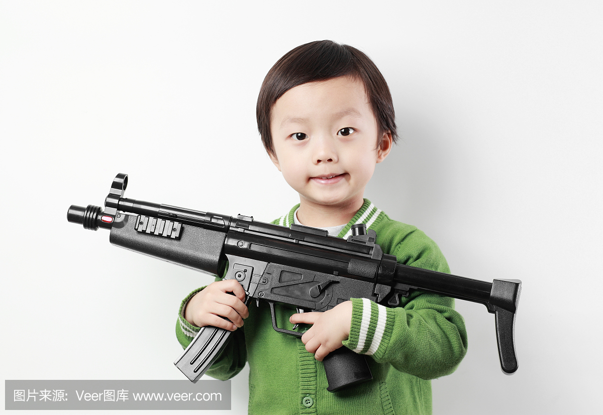 可爱的亚洲孩子玩玩具枪