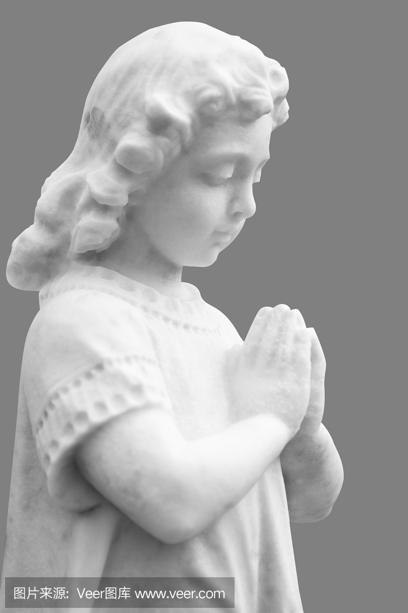 祈祷的小孩的白色大理石雕像在灰色背景上被抛