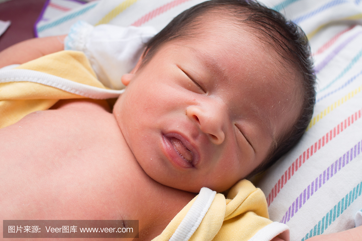 关闭与舌头睡觉的亚洲婴孩伸出