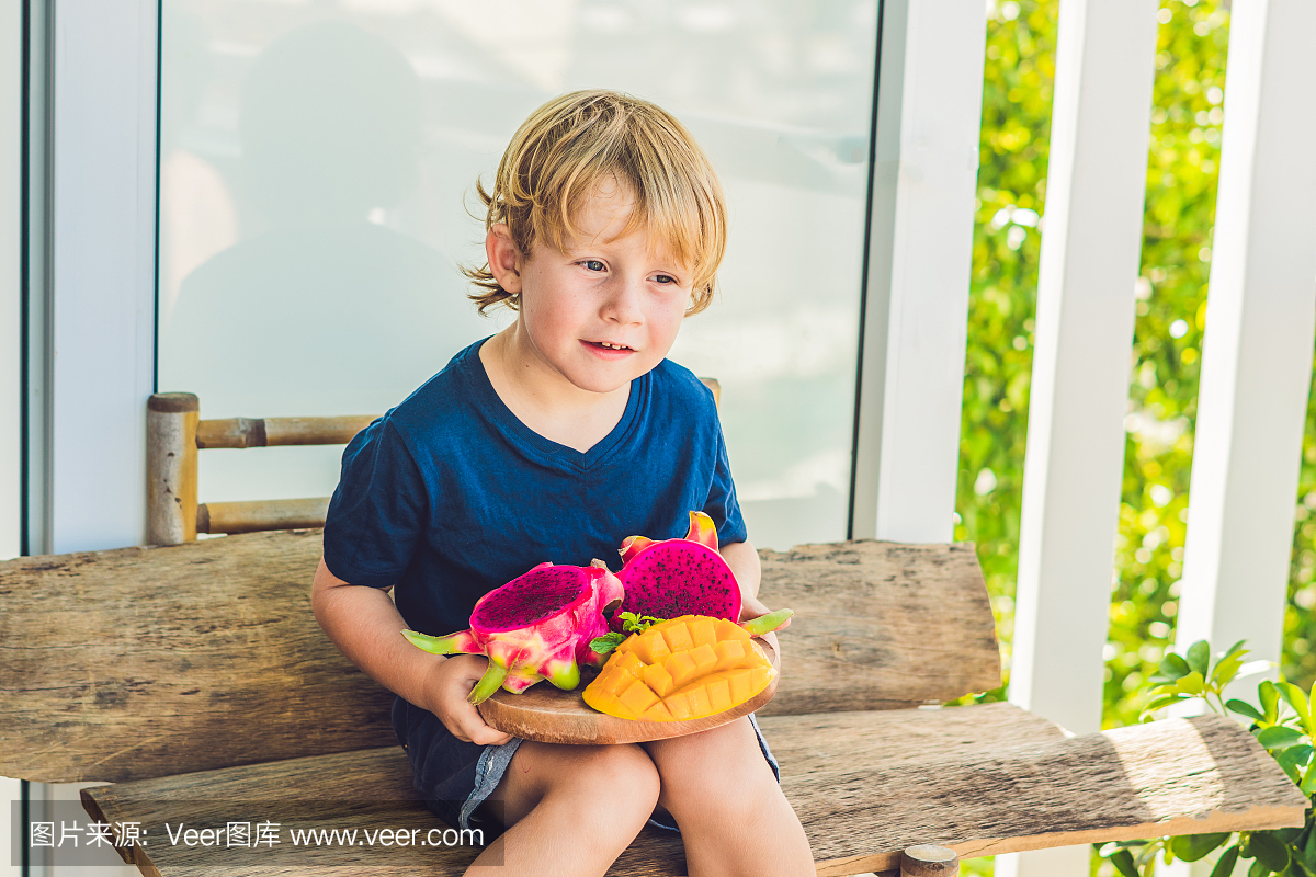 在男孩手中切丁火龙果和芒果