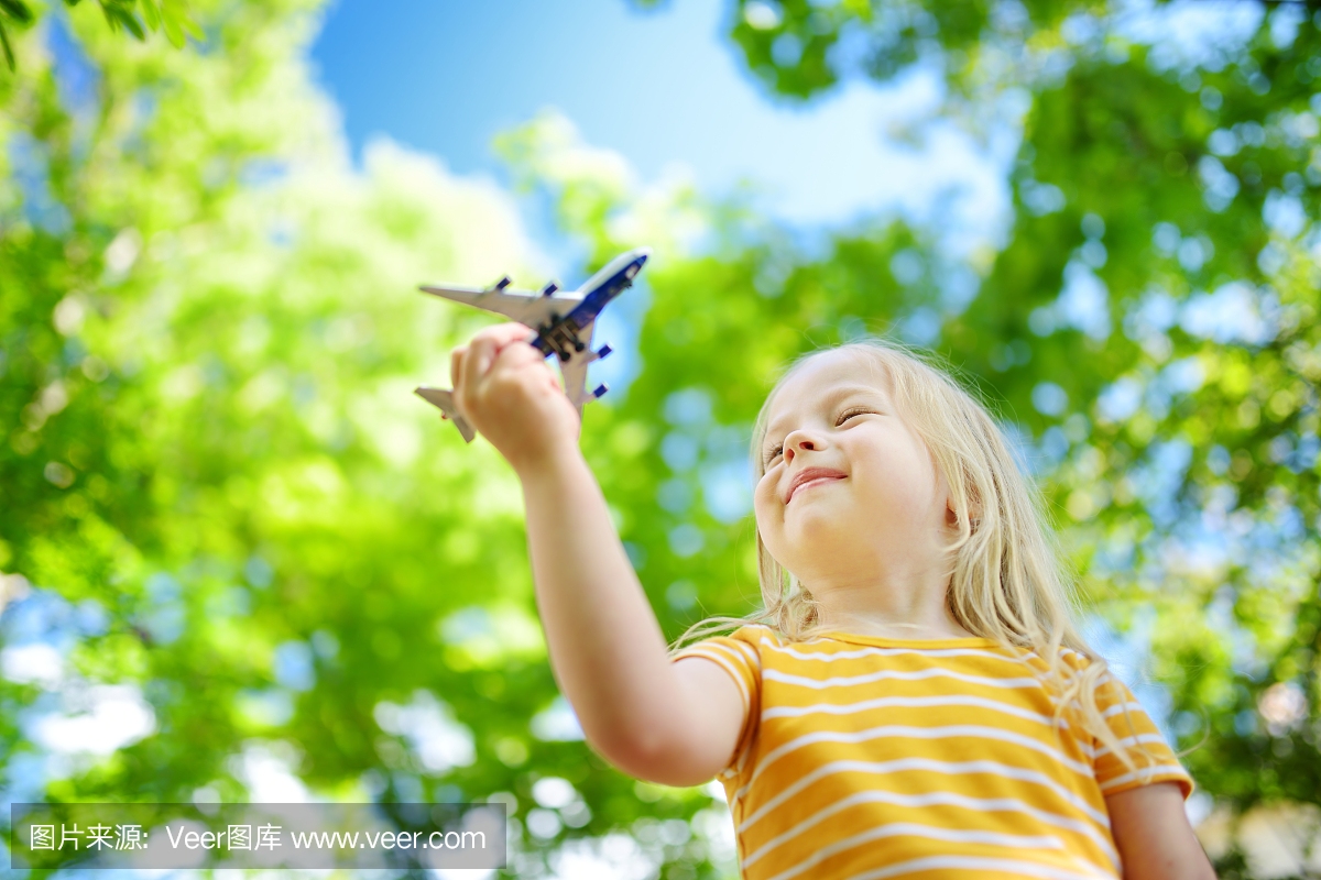 可玩的小女孩玩户外的小玩具飞机