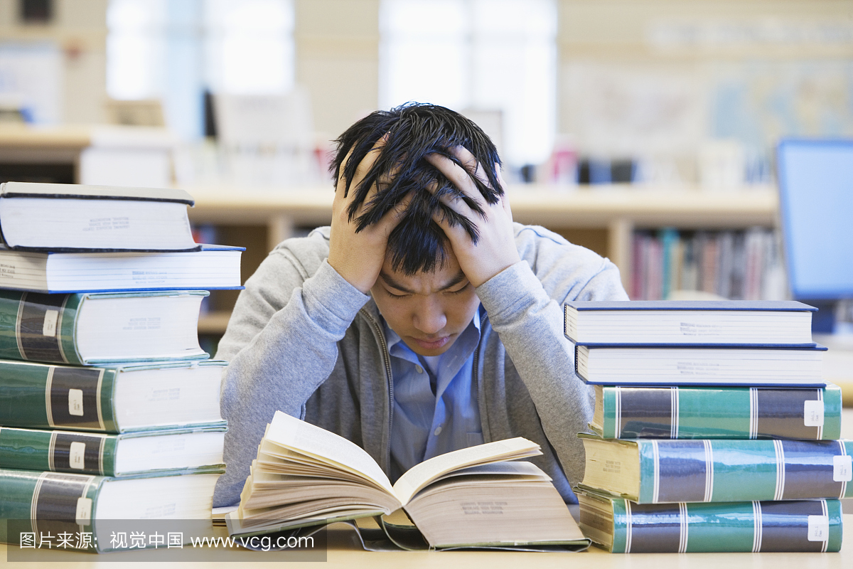 十几岁的男孩(16-17岁)在图书馆的头上