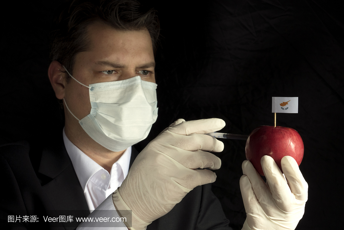 年轻的商人注射化学品到苹果与塞浦路斯国旗在