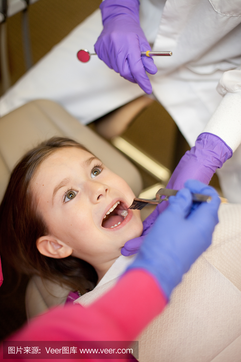 牙医在牙科诊所检查牙齿的女孩