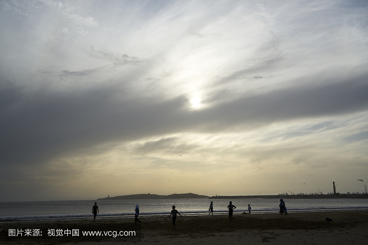 Kida在摩洛哥的索维拉海滩在风和阴天玩足球