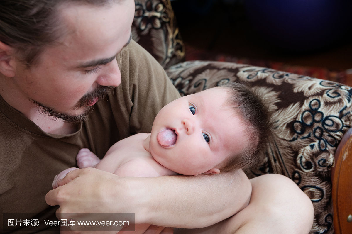 有趣的爸爸和婴儿宝宝一起舌头伸出,幸福的家