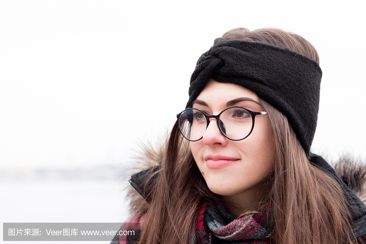 女孩在冬天的衣服,眼镜和温暖的针织头带。美