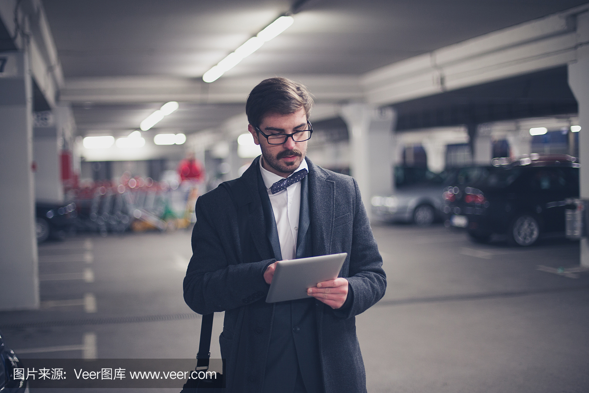 人走在停车场和使用平板电脑
