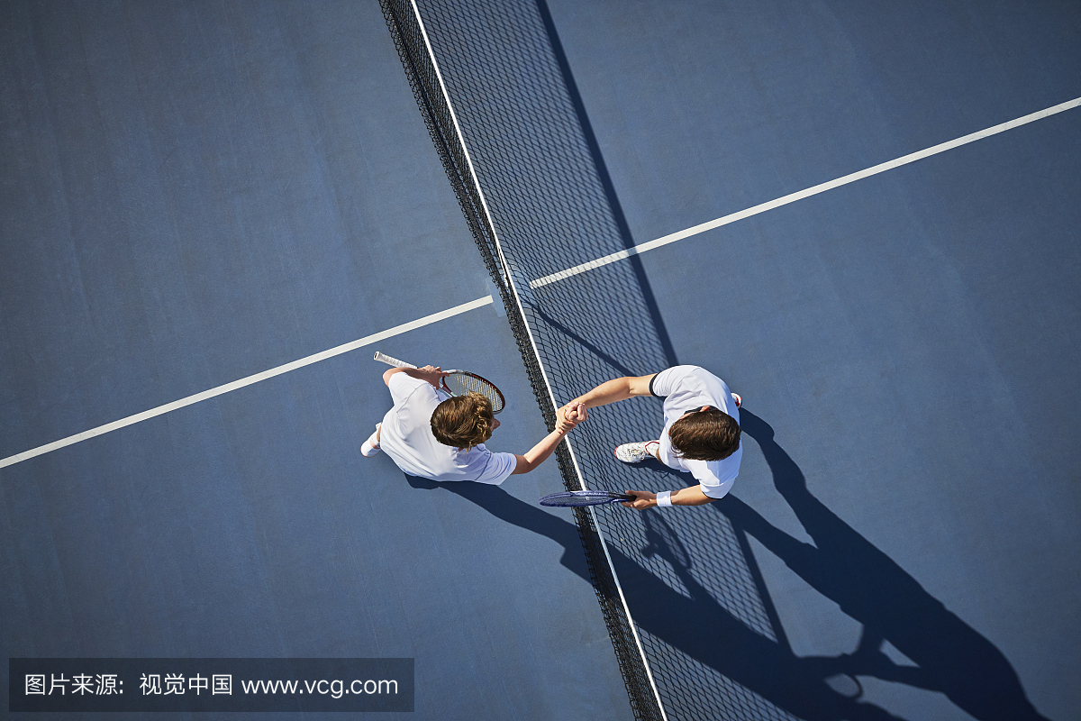 顶视图年轻男性网球选手握手在晴朗的蓝色网球