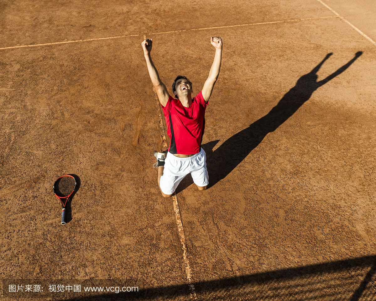 男子网球运动员在膝盖上庆祝胜利