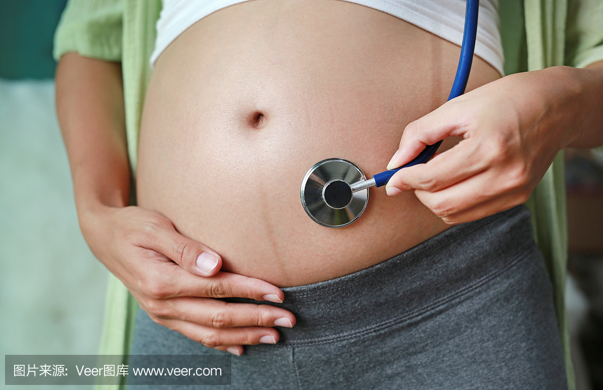 孕妇听听诊器的肚子。