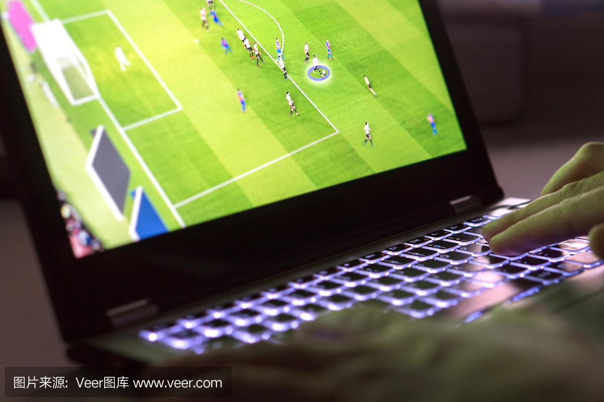 年轻男子玩视频游戏与笔记本电脑。在电脑上的