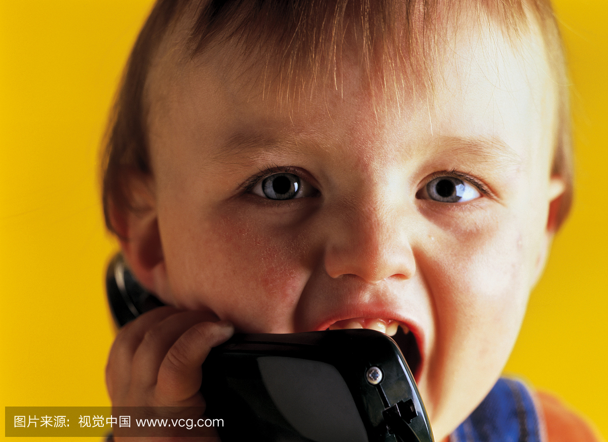持有电话听筒的婴儿肖像(12-18个月)