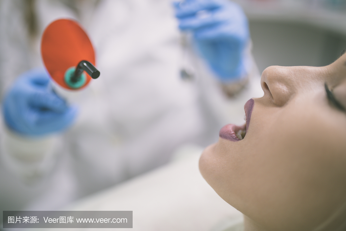 年轻女子患者停止治疗与牙科UV灯设备
