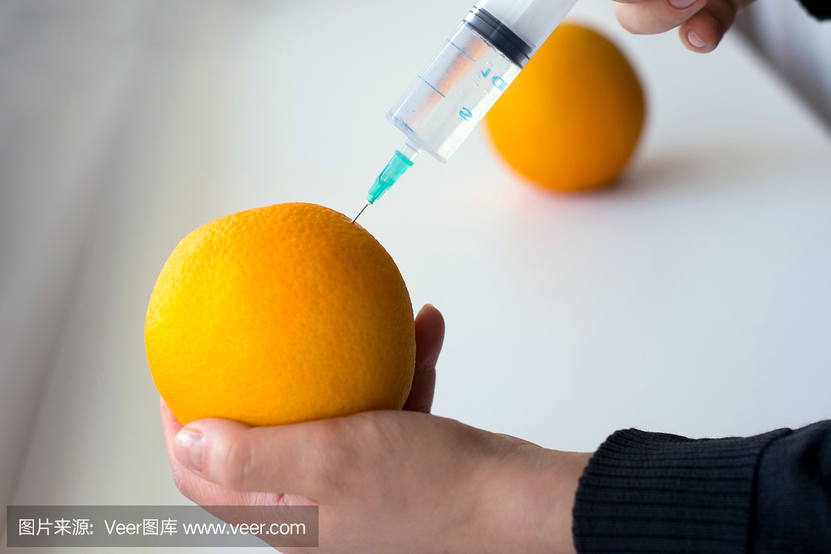 做注射的手的桔子入在轻的女生的一个照片狮子座背景的羊属图片