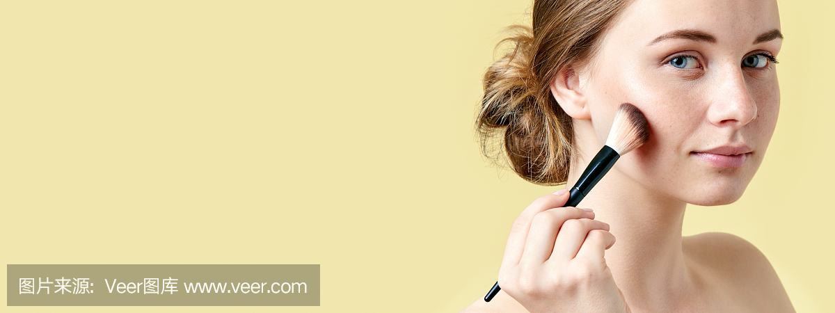 美丽年轻的红发女郎女人与雀斑轮廓使用她的颧