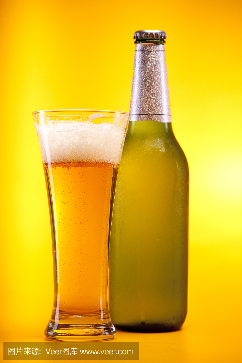 冷黄啤酒在黄色背景