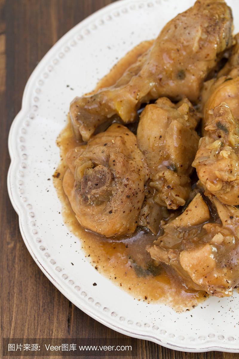 煮熟的鸡肉用白色的板块在棕色的木制背景上