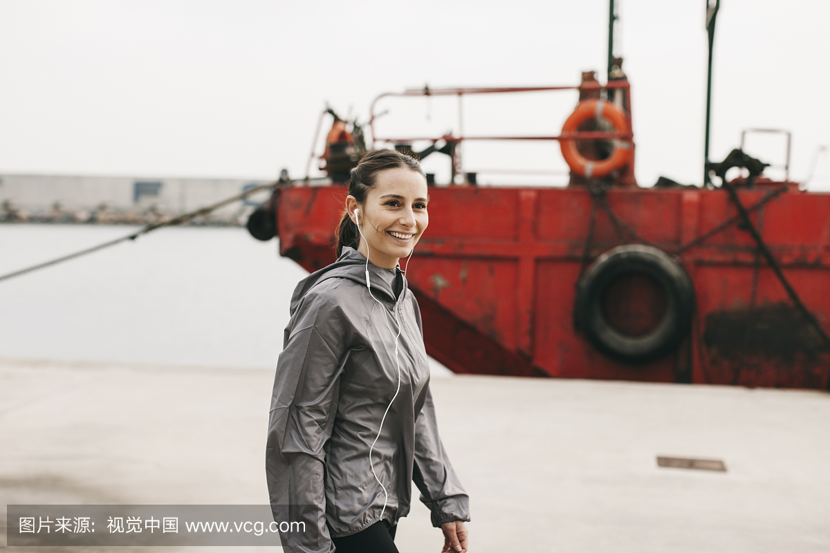 西班牙,巴塞罗那,慢跑的女人耳机在港口