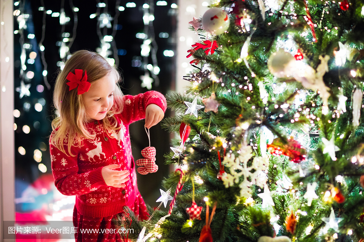 儿童装饰圣诞树在家庭客厅与壁炉
